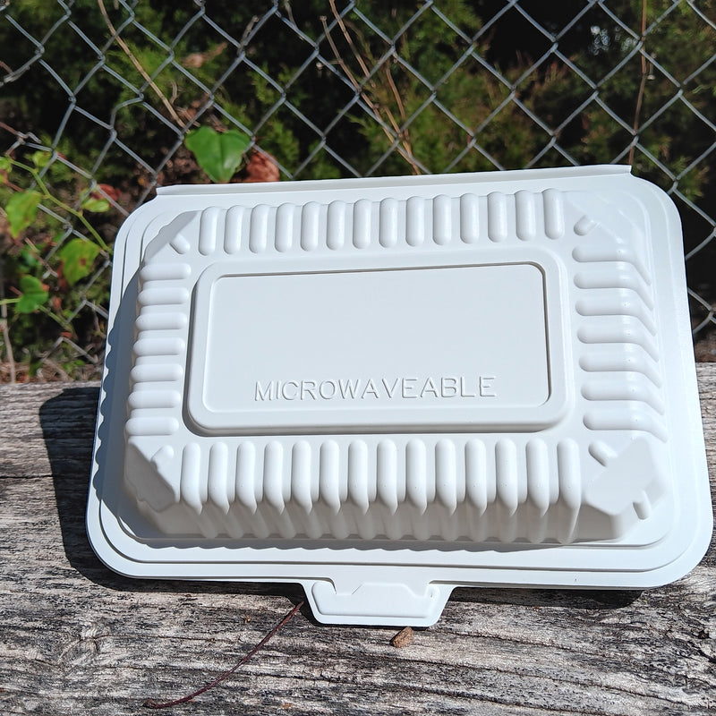 White microwaveable container on a wooden surface with a chain-link fence in the background